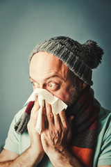 middle-aged bearded man blowing his nose into a napkin, colds, r
