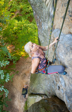 Older Woman Rock Climber Is Holding One Hand In Bag With Powder Chalk Magnesium. View From The Top. Extreme Sports Concept
