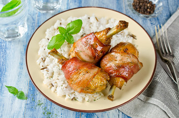 Bacon wrapped chicken legs with rice garnish