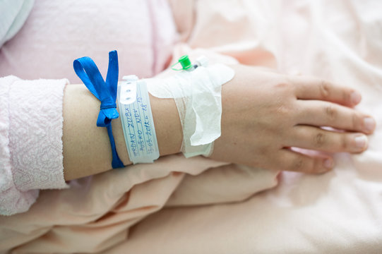 Newborn baby in hospital with id ribbon on his hand