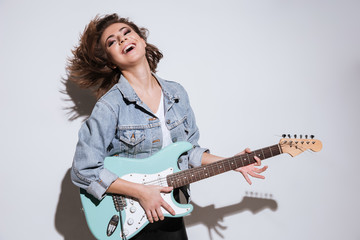 Happy lady holding guitar isolated over white background