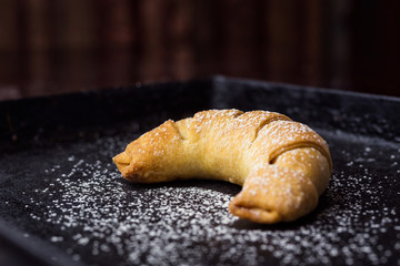 tasty fresh croissants sprinkled with powdered sugar.Delicious continental breakfast with fresh flaky croissants,close up on the croissants.croissant bread on buffet line.Fresh homemade croissants 