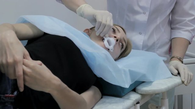 Two doctors prepare the girl to the endoscopy
