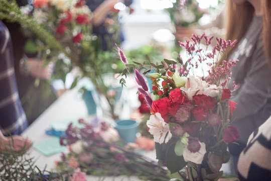 Workshop florist, making bouquets and flower arrangements. Soft focus