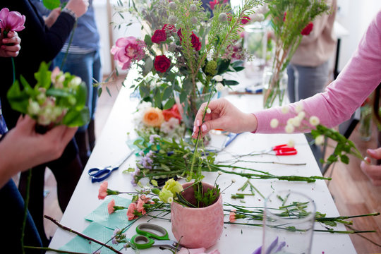 Workshop florist, making bouquets and flower arrangements. Soft focus