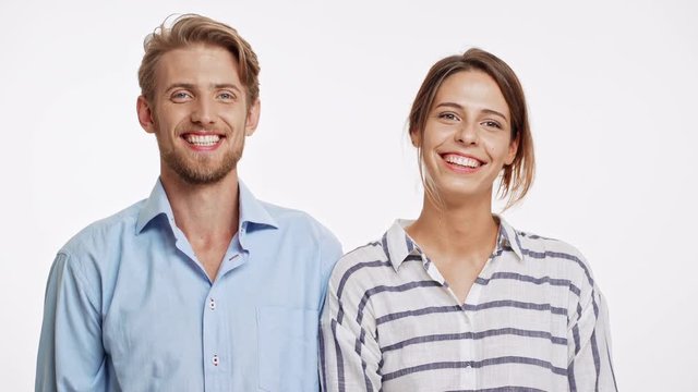 Young Caucasian couple gives high five with one hand to each other and smiling on white background