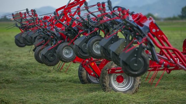 Big agricultural machinery starts fodling together and we can see many wheels on rotary rakes.
