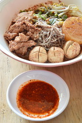 rice vermicelli topping pork ball and meat in brown soup with chili sauce