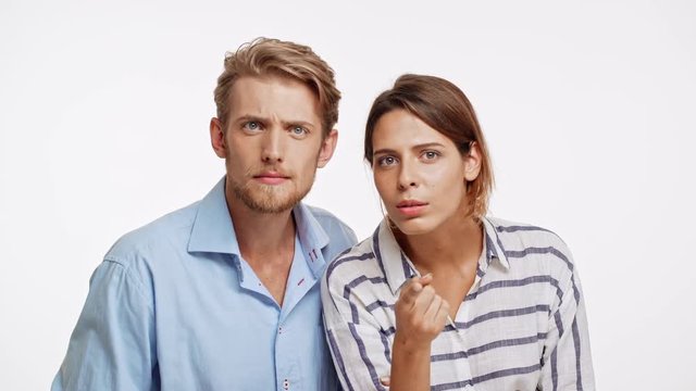 Young Caucasian pair on white background looking at camera choosing and lure someone