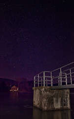 Winter Night Sky with Stars Over Frozen Lake and Pier