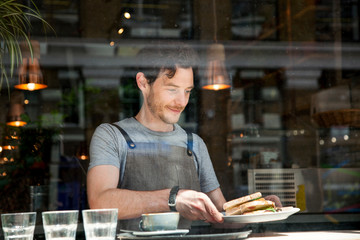 Waiter preparing order at cafe window