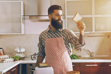 bearded man making toasts with toaster for morning breakfast
