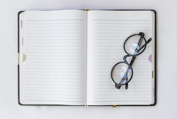 Eyeglasses on blank notebook 