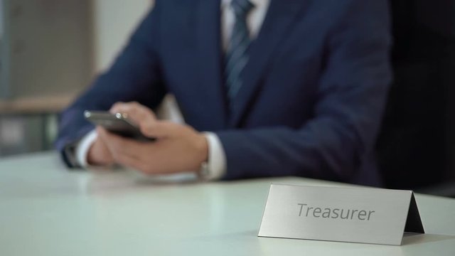 Corporate treasurer using smartphone, planning costs and revenues of company