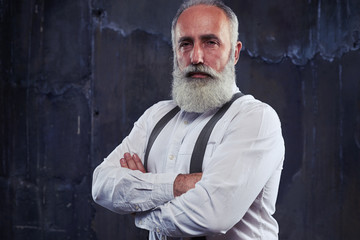 Confident man standing with arms folded isolated in studio