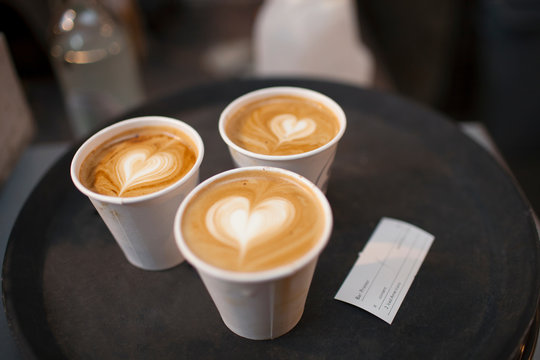 Three takeaway cups of coffee with heart shaped tops