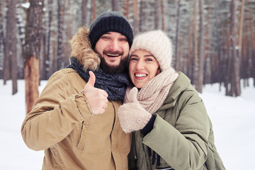Husband and wife showing ok gesture during the winter walk in th