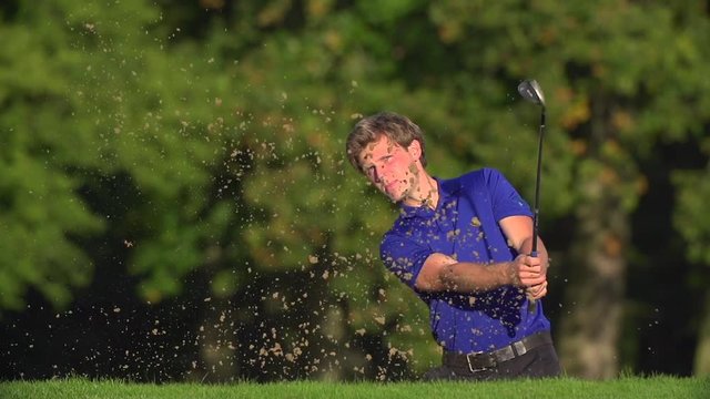 Golfer chips out of Bunker and Celebrates.