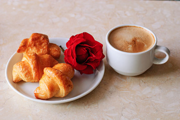 Cup of coffee, croissants and rose on table, romantic breakfast, Valentine Concept