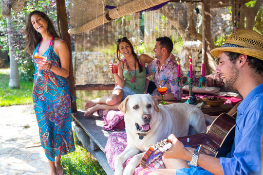 Friends in pergola playing guitar, dancing