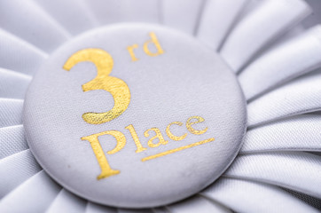 Third place winners white rosette with gold text