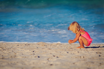 Fototapeta premium cute little girl play with sand on beach