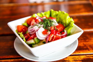 Salad of cucumbers, tomatoes and red onion is in the plate