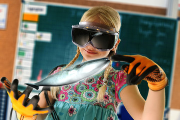 Girl pretending to be teacher wearing virtual reality headset and gloves to show whale