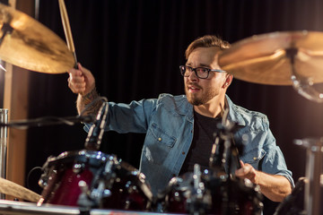 male musician playing drums and cymbals at concert