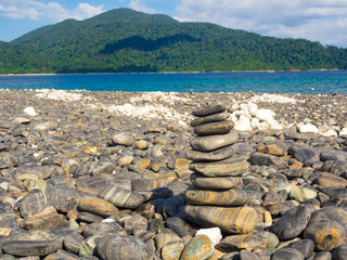 Balance stone on sea beach mountain background