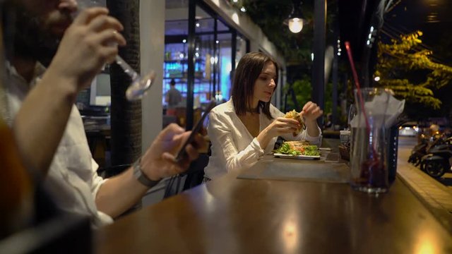 Young Woman Eating Tasty Meal In Cafe At Night
