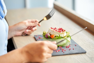 woman eating goat cheese salad at restaurant