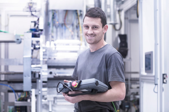 Portrait of engineer holding electronic control equipment in engineering plant
