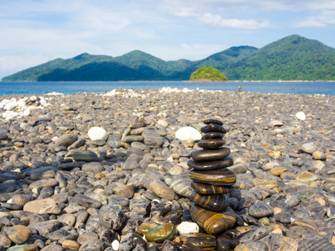 Balance stone on sea beach mountain background