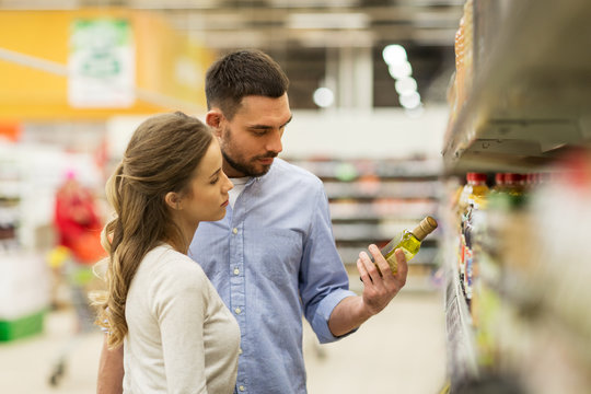 happy couple buying olive oil at grocery store - Powered by Adobe