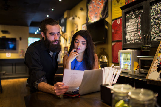 Young couple reading menu at public house table
