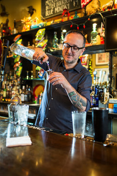 Barman preparing cocktail at public house counter