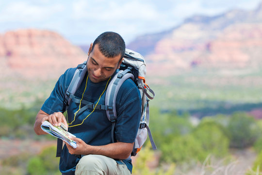 Young male hiker looking at map, Sedona, Arizona, USA