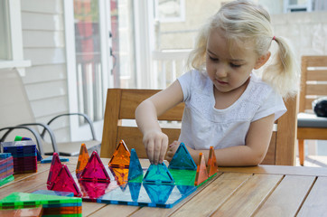 Young girl playing with triangular building shapes