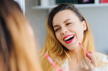 young woman applying lipstick