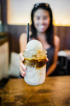 Young woman holding coffee float at Farm to Table, Bangkok, Thailand