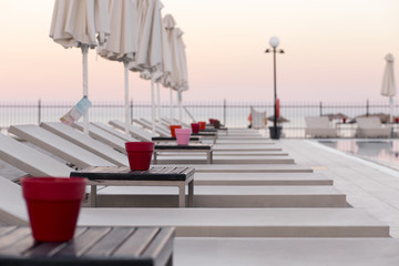 A set of beach chair in a hotel's pool at sunset