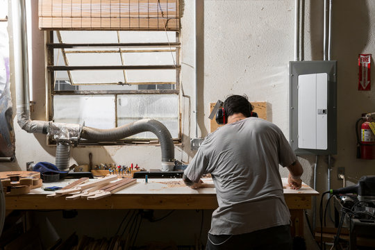 Guitar maker manufacturing guitar in workshop