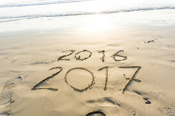 Happy New Year 2017 replace 2016 concept on the sea beach