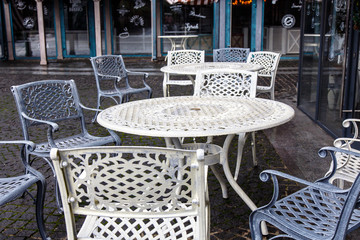 Empty metal tables and chairs in a street cafe in the fall.