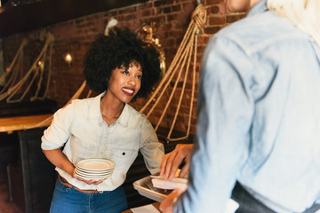 Colleagues in restaurant preparing place settings