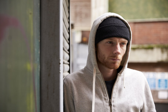 Thoughtful young man leaning on wall outdoors