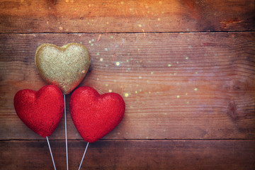 red glitter hearts on wooden background