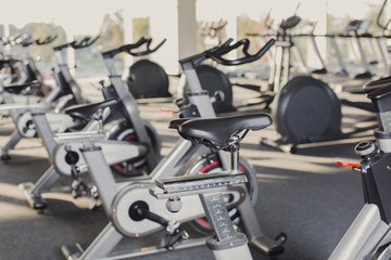Fototapeta na wymiar Modern gym interior with equipment, fitness exercise bikes
