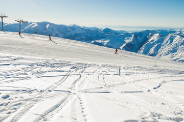 Fototapeta na wymiar Ski run with amazing view on Caucasus Mountain range. Skiing resort. Extreme sport. Active holiday. Free time, travel concept. Copy space